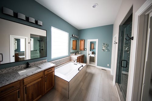 Bathroom with teal wall and wooden flooring