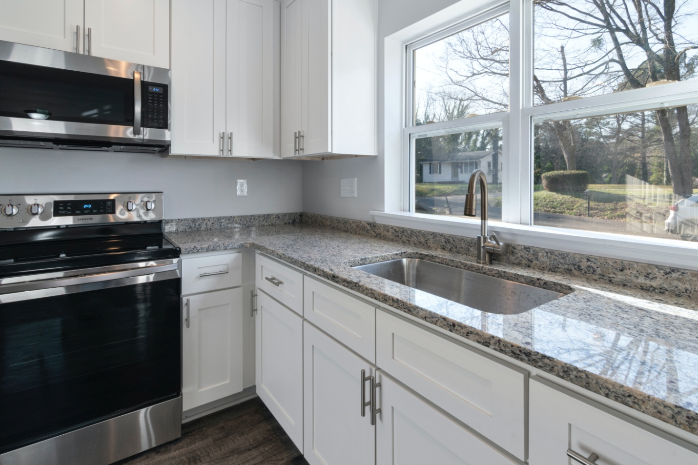 White wooden kitchen cabinets with granite countertops