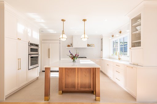 a white kitchen with a wooden center island