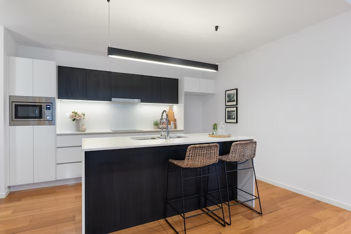 two-toned black and white kitchen cabinet theme with wooden floors